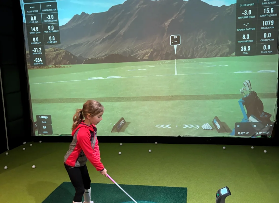 Junior golfer practising in a golf simulator at Pure Swing Hersham